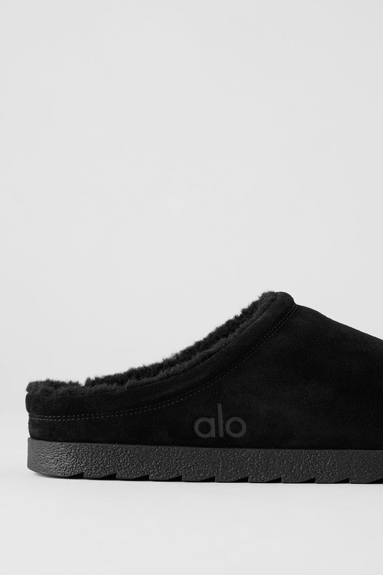 Alo Recovery Slipper in the black suede color with a faux fur lining.