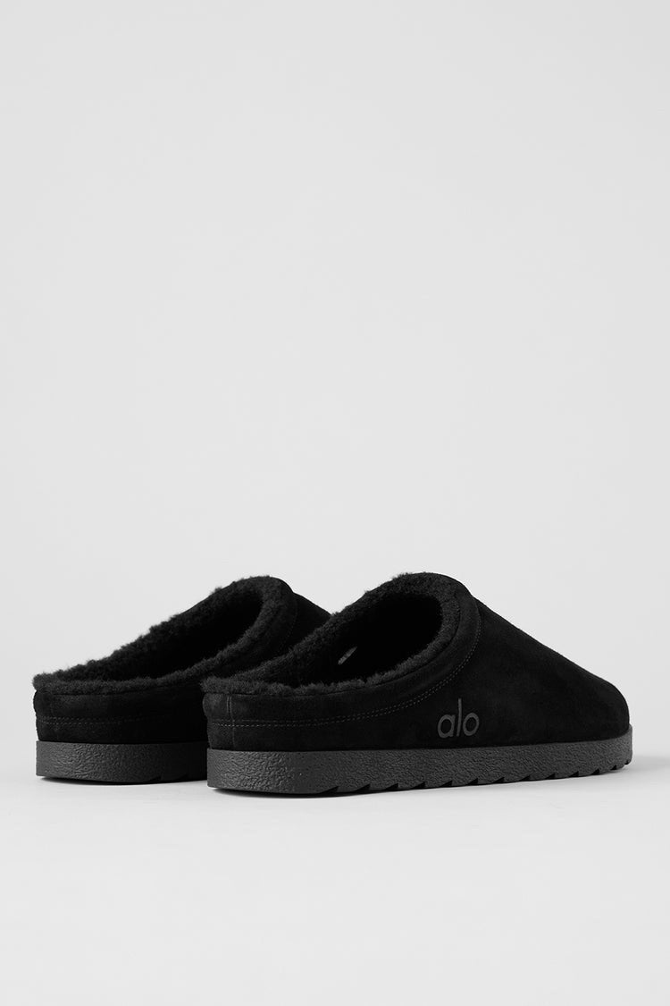 Alo Recovery Slipper in the black suede color with a faux fur lining.